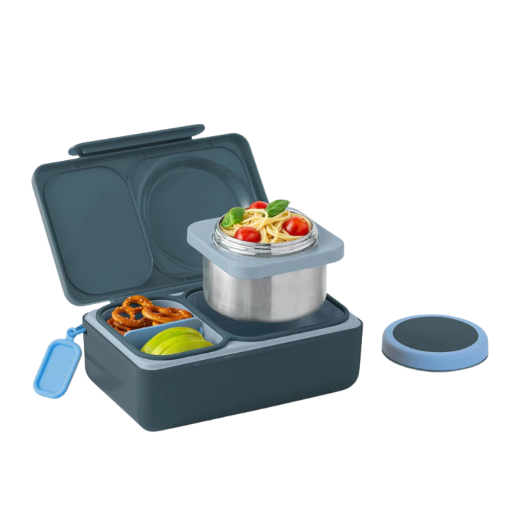Omie UP grey lunch box with compartments containing food items on a white background