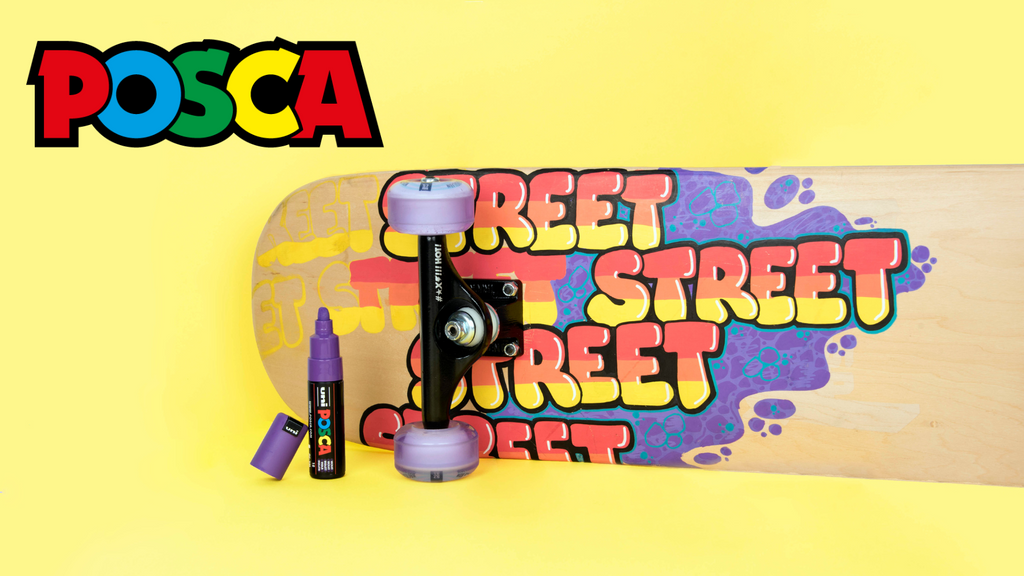 Skateboard with colourful 'Street' text design and POSCA markers on a yellow background for school art projects
