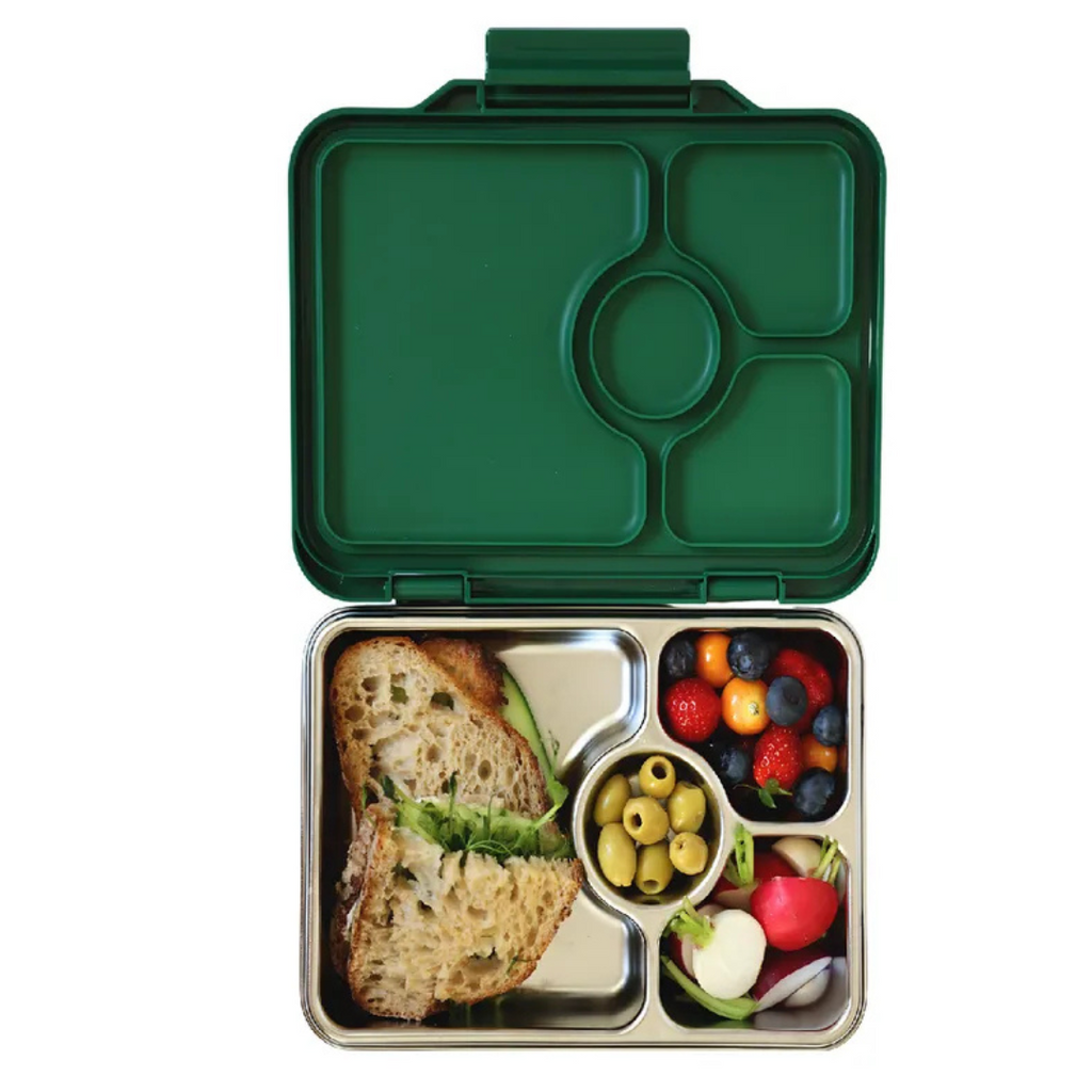 Yumbox Pret stainless steel Dublin Green bento box with compartments containing a sandwich and fresh fruits and vegetables on a white background